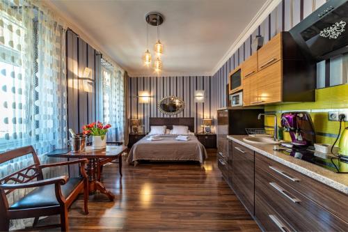 a hotel room with a bed and a table and a kitchen at Apartamenty Boutique in Ustka