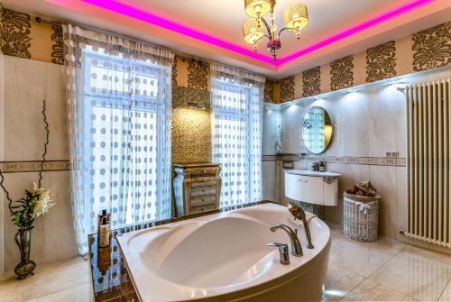 a large bathroom with a large tub and a window at Apartamenty Boutique in Ustka