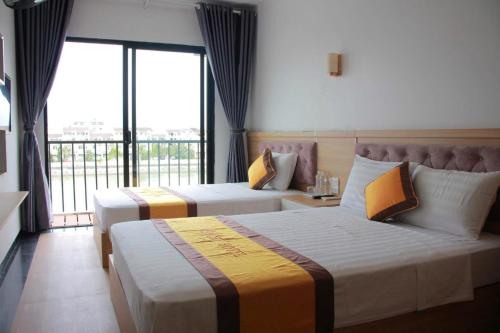 a hotel room with two beds and a balcony at A59 Memory Hotel Tuan Chau in Ha Long