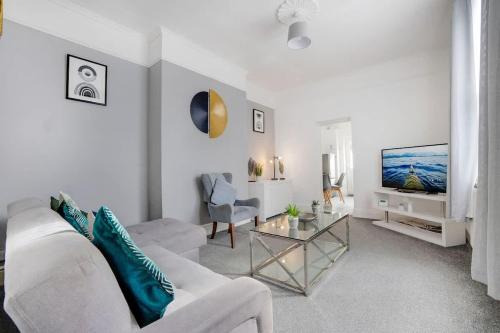 a living room with a white couch and a tv at Spacious 3-Bed Home in South Shields, Sleeps 8 in South Shields