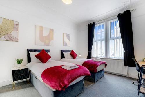 a bedroom with two beds with red pillows at Spacious 3-Bed Home in South Shields, Sleeps 8 in South Shields