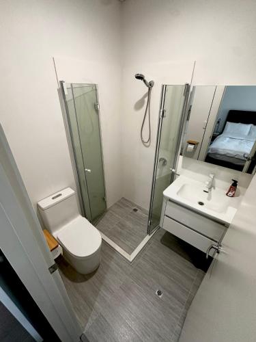 a bathroom with a toilet and a shower and a sink at June Stay in Perth