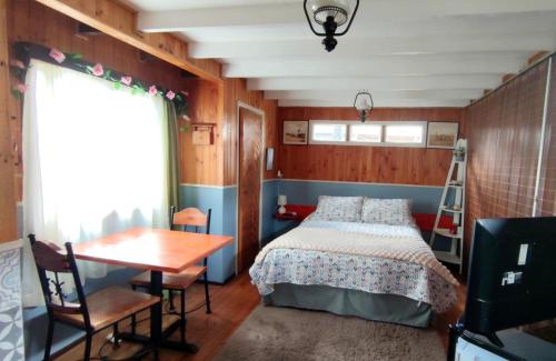 a bedroom with a bed and a table and a ladder at Victoria Cabin in Victoria