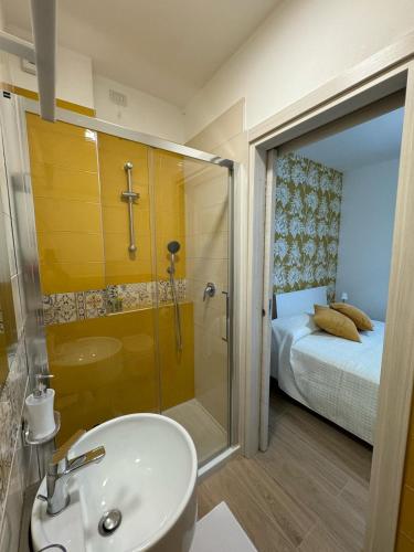 a bathroom with a sink and a shower and a bed at Agriturismo Belfiore in Castelnuovo Magra