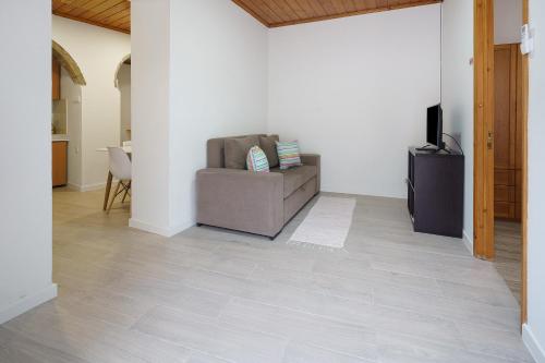 a living room with a couch and a television at Casa Flor de Laranjeira in Faial da Terra