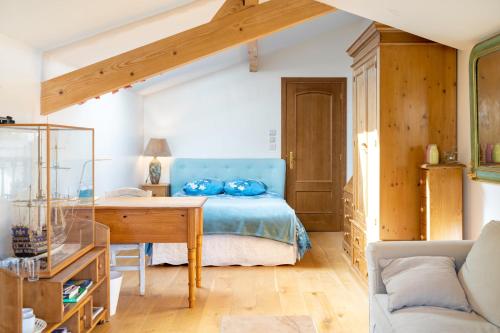 a bedroom with a blue bed and a wooden desk at Chambre d'hôtes d'Émilie in Anglet