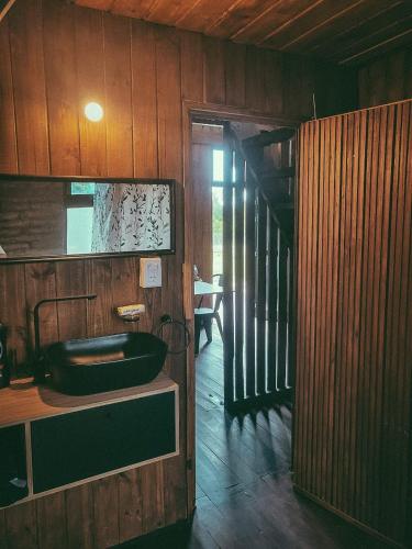 a bathroom with a sink and a wooden wall at La Empinada in Bialet Massé