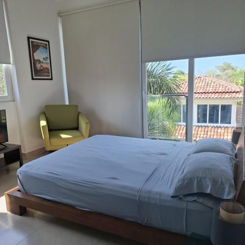a bedroom with a bed and a chair and a window at Rio Mar Villages in San Carlos