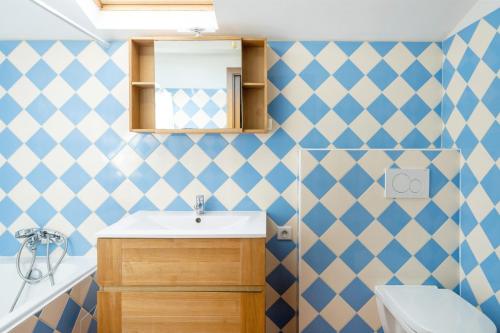 a bathroom with blue and white tiled walls and a sink at Chambre d'hôtes d'Émilie in Anglet