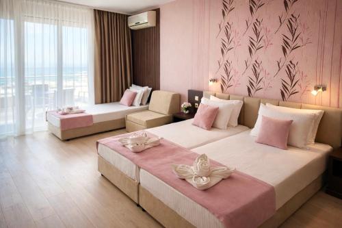 a hotel room with two beds with flowers on them at Hotel Ancora Beach in Primorsko