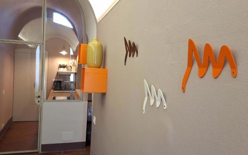a kitchen with orange accents on the wall at Sky Loft La Melissa - Pisa Center in Pisa