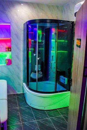 a shower in a bathroom with a green andorescent at Soulmate Hotels and Suites in Mawere