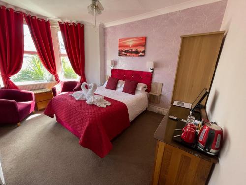 a bedroom with a bed with a red bedspread at The Ashleigh in Paignton