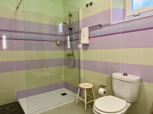 a bathroom with a toilet and a shower and a stool at Casa Varanda do Mar in Capelas