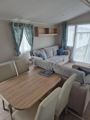 a living room with a table and a couch at Sharmar Eyemouth in Eyemouth