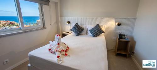 ein Schlafzimmer mit zwei Betten und Meerblick in der Unterkunft Hotel São Mamede Estoril in Estoril