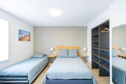 a bedroom with two beds and a book shelf at Chambres D'hôtes Madan'hôte in Capbreton