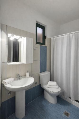 a bathroom with a white sink and a toilet at Zen Villas in Nikiana