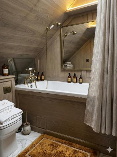 a bathroom with a bath tub and a toilet at La'Mansarda in Chişinău