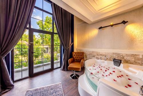 a bedroom with a tub and a large window at WM Cappadocia in Nevşehir