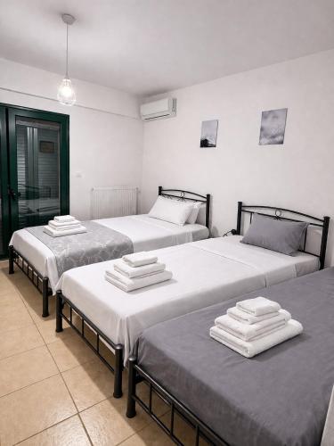 a room with three beds with towels on them at Zen Villas in Nikiana