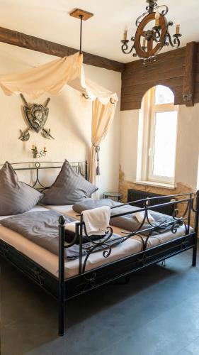 a large bed in a bedroom with a chandelier at Pension Arietta in Plauen
