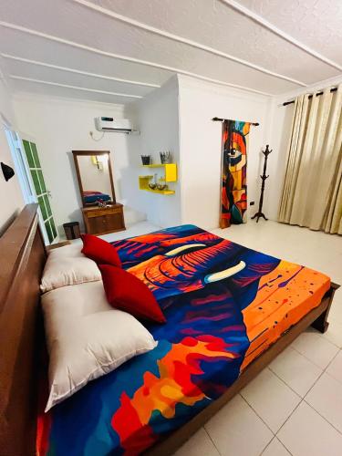 a bedroom with a bed with a colorful blanket at Benthota grand villa in Nakandalagoda