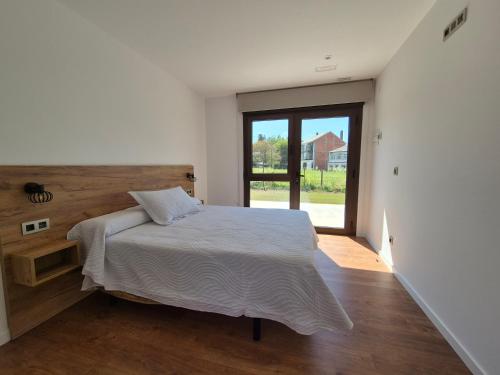 a bedroom with a bed and a large window at Pensión Agro da Porta in Palas de Rei