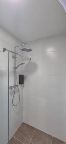 a bathroom with a shower with a glass door at Pensión Agro da Porta in Palas de Rei