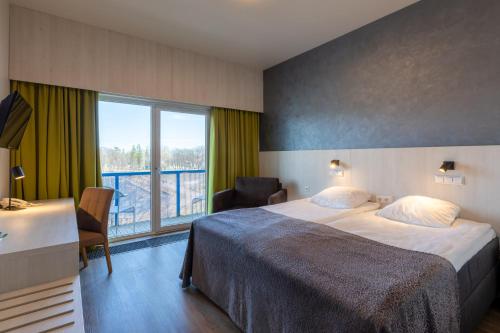 a hotel room with a bed and a large window at Viiking Spa Hotel in Pärnu
