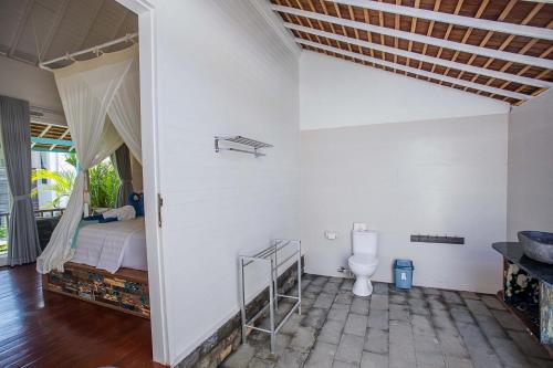 a bedroom with a bed and a toilet in a room at Water Blow Huts in Nusa Lembongan
