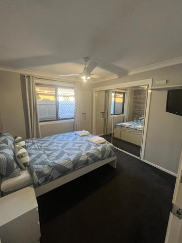 a bedroom with a bed and a large mirror at Coomera Private Rooms near DreamWorld in Gold Coast