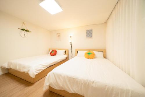 two beds in a small room with white walls at Banghwa Space 5 min to Banghwa Stn, Near Gimpo Airport, Magok & COEX in Seoul