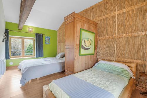 two beds in a room with green walls at Gîte Le Jardin Mirandou in Raucoules