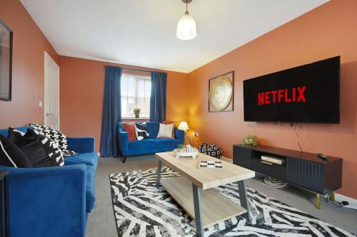 a living room with a tv and a blue couch at Stylish Teesside Home Ideal for Work or Leisure in Stockton-on-Tees