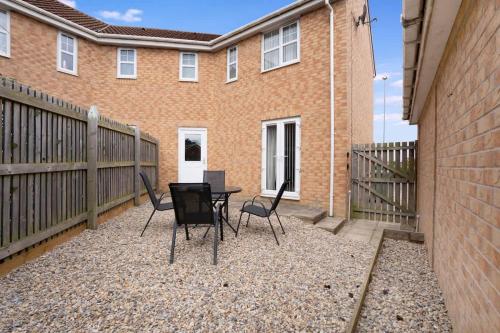 a patio with chairs and a table in front of a building at Stylish Teesside Home Ideal for Work or Leisure in Stockton-on-Tees
