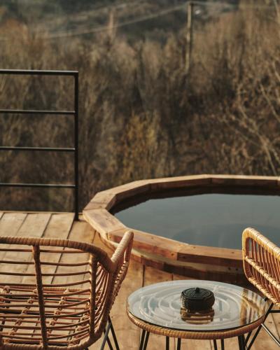 a patio with a table and chairs and a hot tub at BRUN Cabin in Şotrile