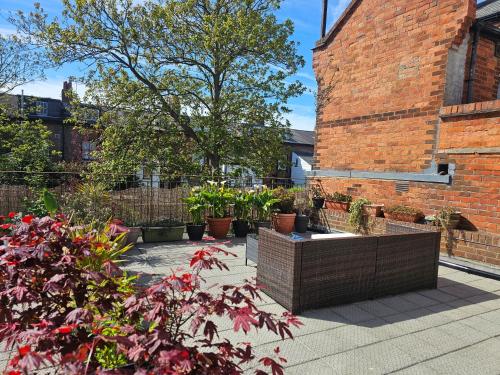 a courtyard with potted plants and a brick building at Coastal Terrace Retreat- Allocated Parking, 2 Bedrooms in Portsmouth