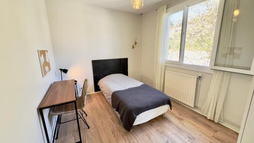 a bedroom with a bed and a desk and a window at Maison en colocation, 2 salles de bains & WC, Wifi, Parking, proche CHU & Limoges in Isle