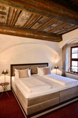 a bedroom with a large bed with a wooden ceiling at Pension Donatus in Pirna