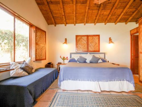 een slaapkamer met 2 bedden in een kamer met ramen bij Casitas Pacificas in Máncora