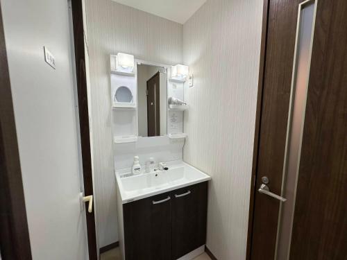 a bathroom with a sink and a mirror at つんまぁー家 in Miyakojima