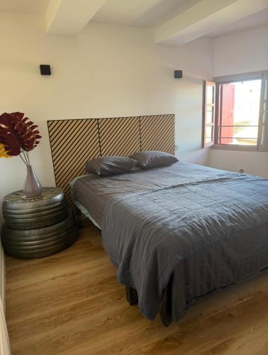 a bedroom with a bed and a vase with a flower at Agde centre historique avec vue in Agde