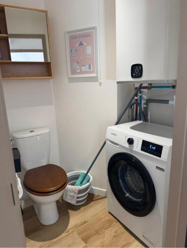 a bathroom with a washing machine and a toilet at Agde centre historique avec vue in Agde