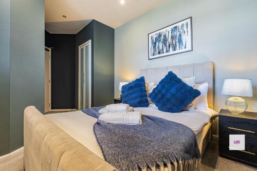 a bedroom with a large bed with blue pillows at Brighton central stylish stays. Walk to the beach. in Brighton & Hove