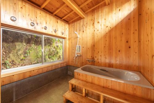 a bathroom with a large tub and a window at 宿坊 大泰寺 Temple Hotel Daitai-ji in Nachikatsuura
