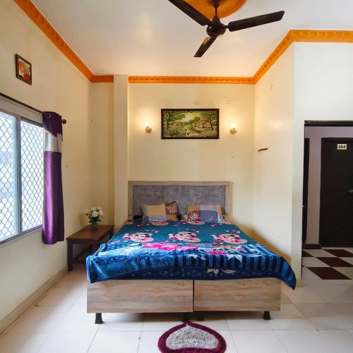 a bedroom with a bed and a ceiling fan at Hotel B B Pride in Raipur