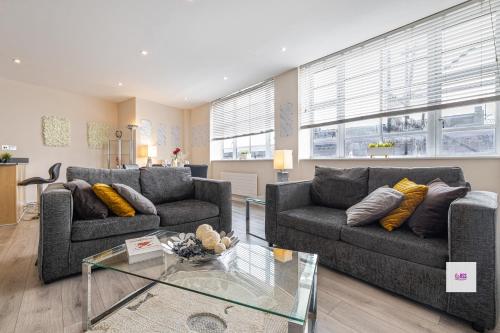 a living room with two couches and a glass table at Brighton Central Perfect Stays Walk to the Beach in Brighton & Hove