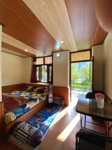 a bedroom with a bed and a table in a room at Nature Nest in Manāli