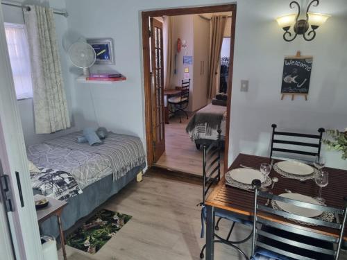 a bedroom with a bed and a table and a dining room at Twelveon1st in Cape Town